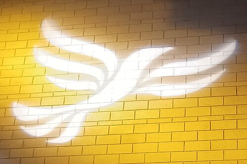 Lib Dem logo bird projected on blockwork